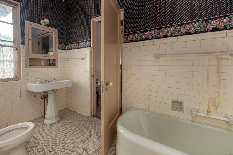 Bathroom featuring a bath, tile walls, tile patterned flooring, and toilet