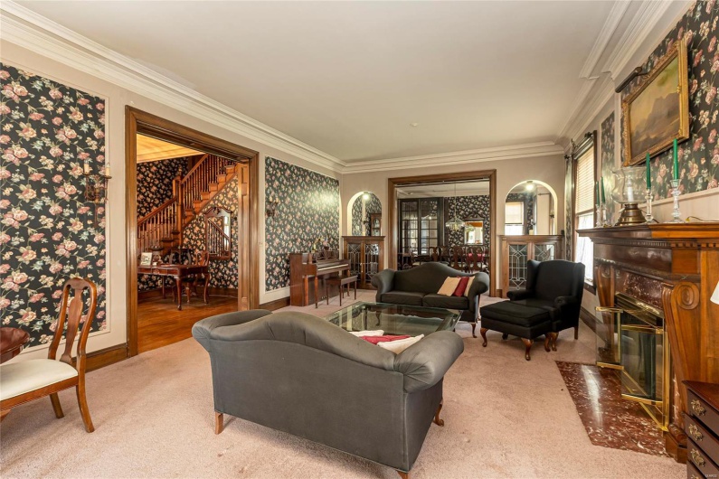 Living room with carpet floors and ornamental molding