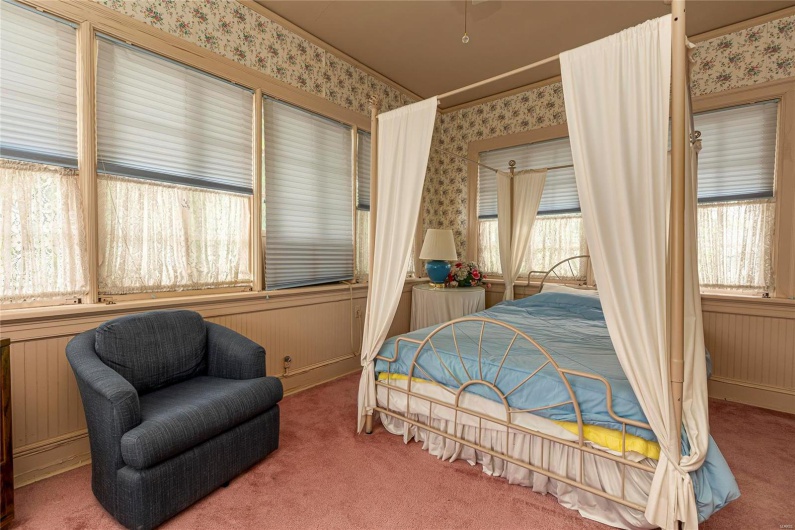 Bedroom featuring carpet floors and wood walls