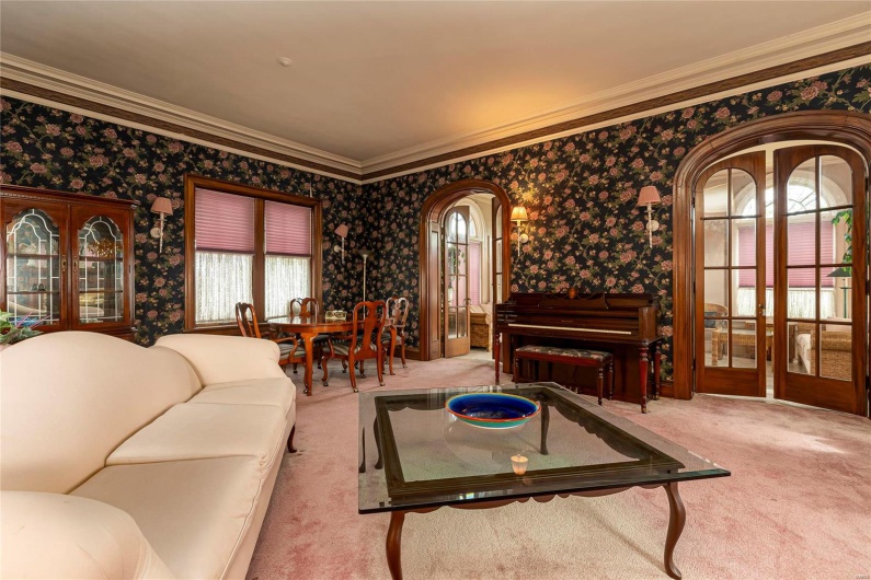 Living room with light colored carpet and ornamental molding