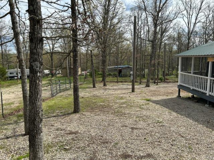 View of yard with a sunroom and fence