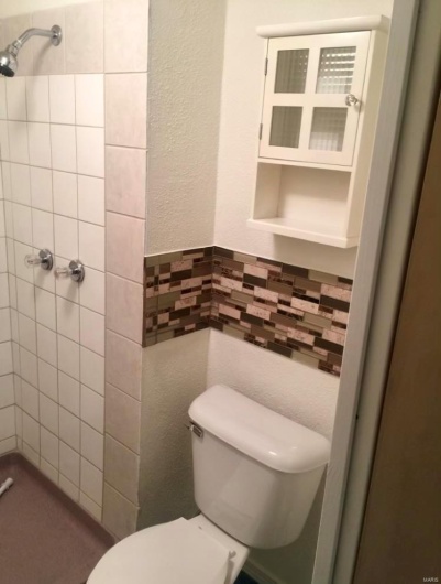 Bathroom with a tile shower and toilet
