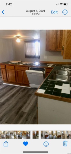 Kitchen featuring dark hardwood / wood-style floors, sink, tile countertops, and dishwasher