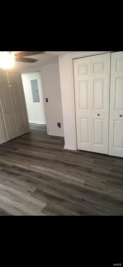 Unfurnished bedroom featuring electric panel, a closet, dark hardwood / wood-style flooring, and ceiling fan