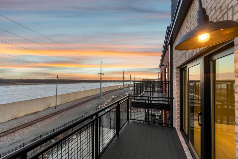Balcony at dusk featuring a water view