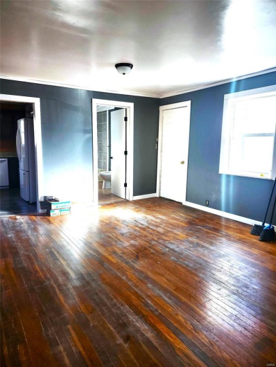 Unfurnished room featuring ornamental molding, baseboards, and hardwood / wood-style floors