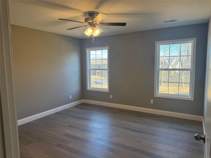 Empty room featuring ceiling fan and dark wood-type flooring