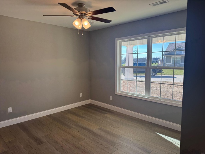 Spare room featuring hardwood / wood-style flooring, a wealth of natural light, and ceiling fan