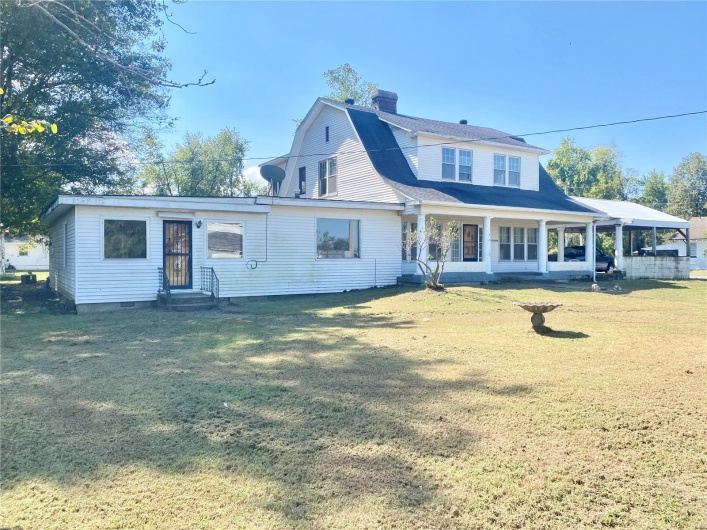 Rear view of house with a porch and a yard