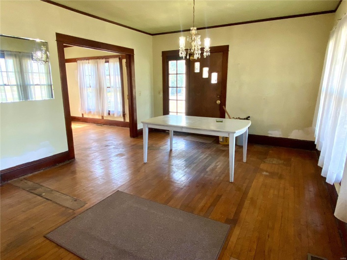 Unfurnished dining area featuring ornamental molding, a chandelier, and hardwood / wood-style flooring