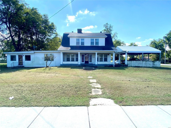 View of front facade featuring a front lawn and covered porch