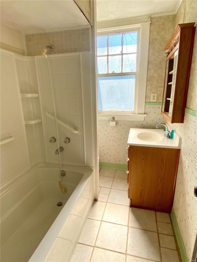 Bathroom featuring tile patterned flooring, vanity, and bathtub / shower combination