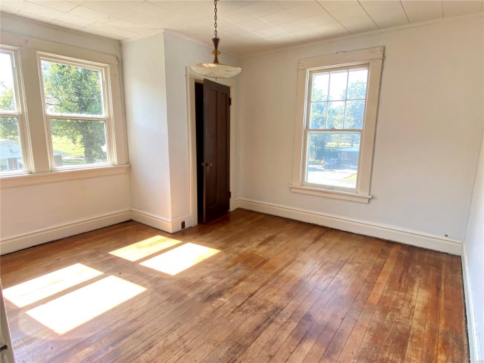 Spare room with a healthy amount of sunlight, ornamental molding, and wood-type flooring