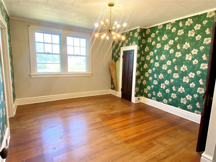 Unfurnished room featuring an inviting chandelier, hardwood / wood-style flooring, and ornamental molding