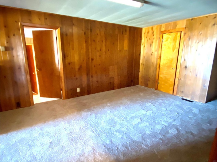 Spare room featuring wood walls