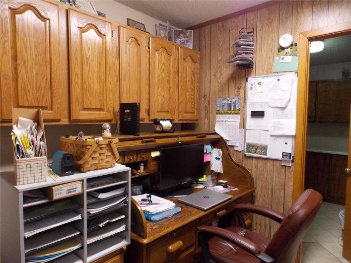 Tiled home office featuring a textured ceiling and wood walls
