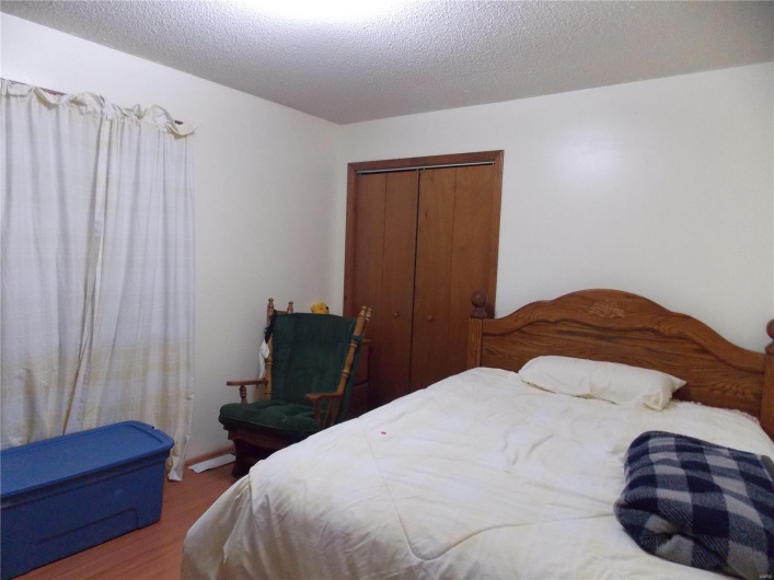 Bedroom featuring a textured ceiling, a closet, and hardwood / wood-style floors