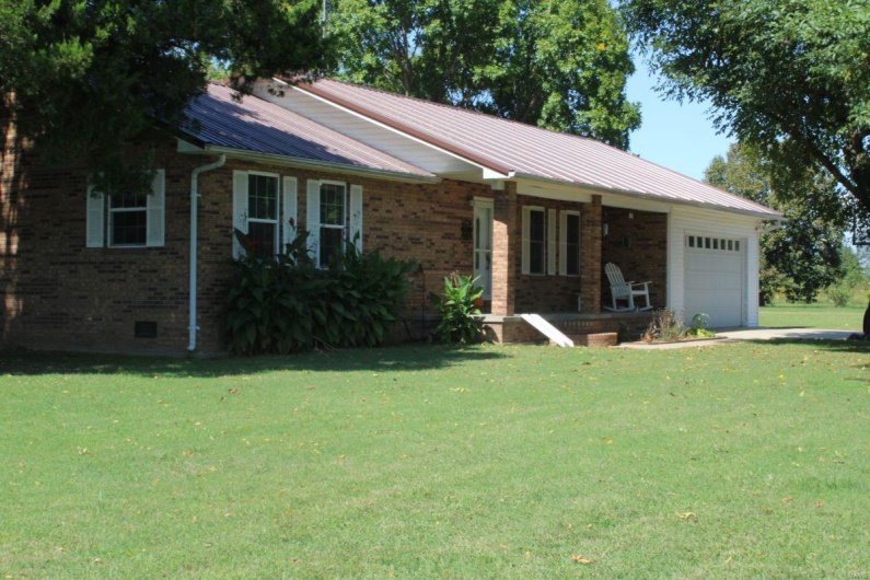 Ranch-style home featuring a garage and a front lawn