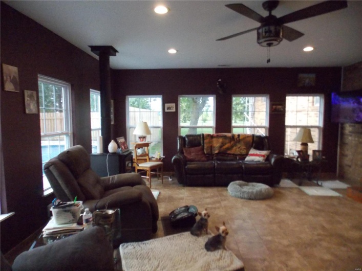 Living room with ceiling fan and a wood stove