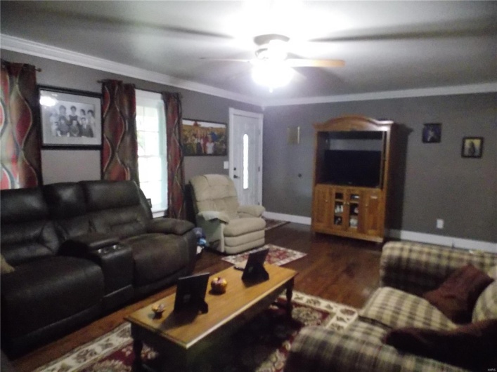 Living room featuring ornamental molding, hardwood / wood-style floors, and ceiling fan