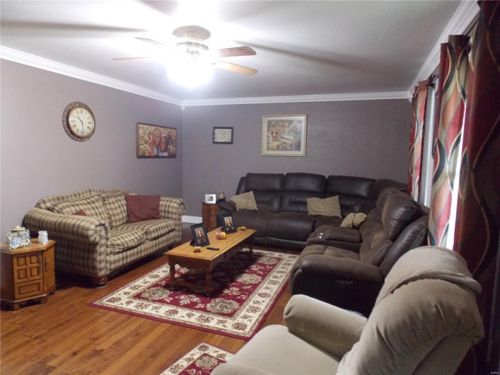 Living room featuring ceiling fan, ornamental molding, and hardwood / wood-style floors
