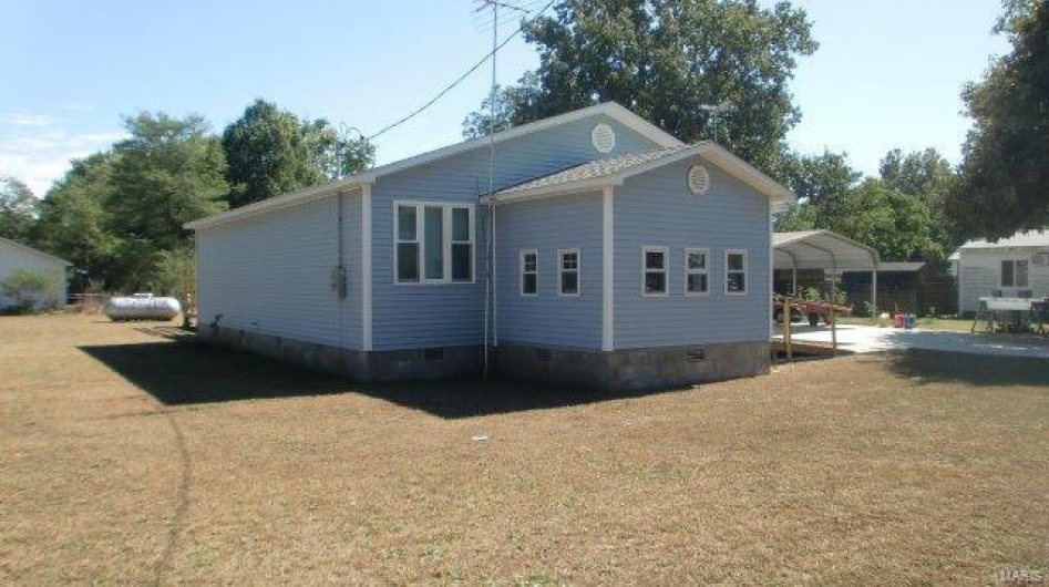 View of property exterior featuring a yard and a carport