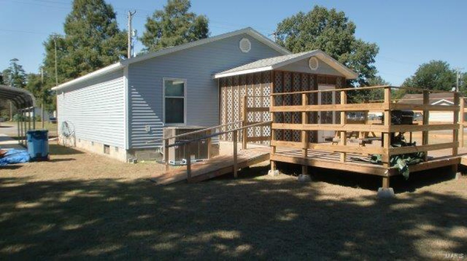 Back of property featuring a deck and central AC