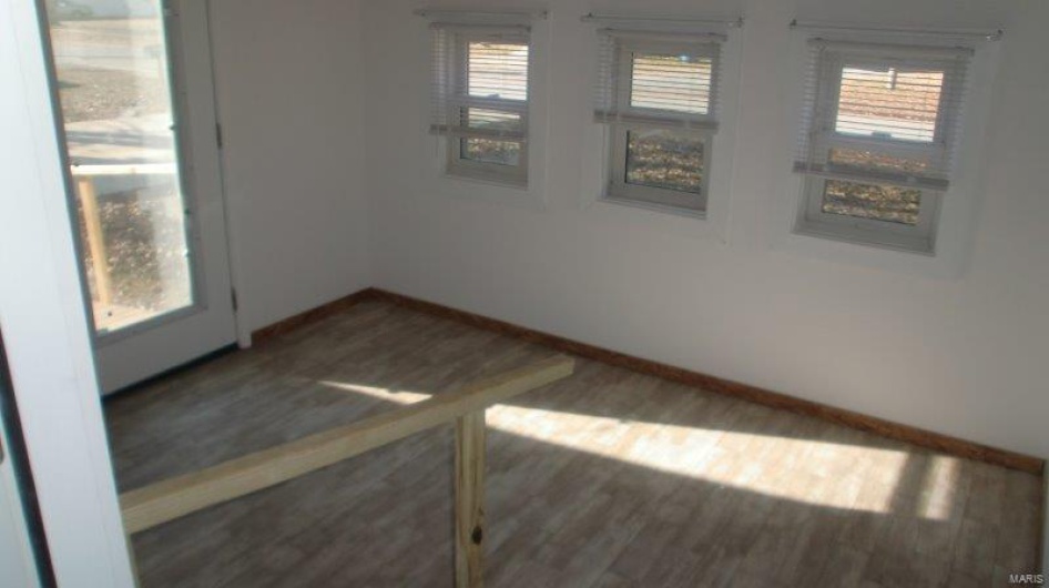 Unfurnished room with dark hardwood / wood-style floors and a wealth of natural light