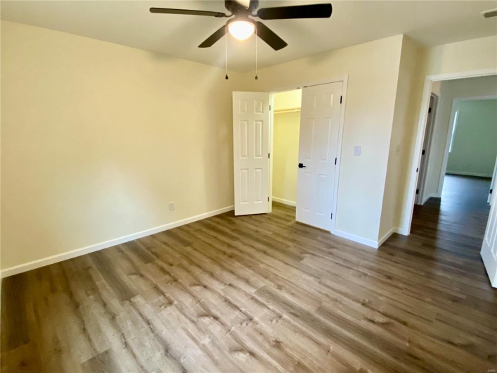 Unfurnished bedroom featuring a closet, hardwood / wood-style floors, and ceiling fan