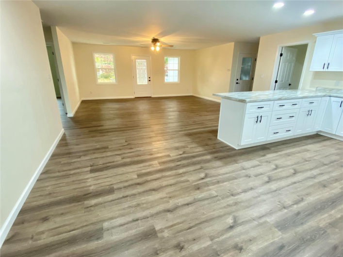 Kitchen with ceiling fan, kitchen peninsula, light wood-type flooring, and white cabinets