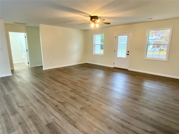 Unfurnished living room with dark hardwood / wood-style floors and ceiling fan