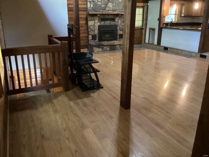 Living room featuring a stone fireplace and light wood-type flooring