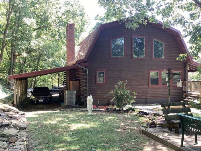 View of property exterior with a wooden deck, central AC, and a yard