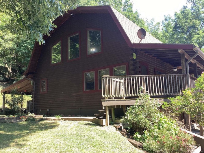 View of side of home featuring a deck and a yard