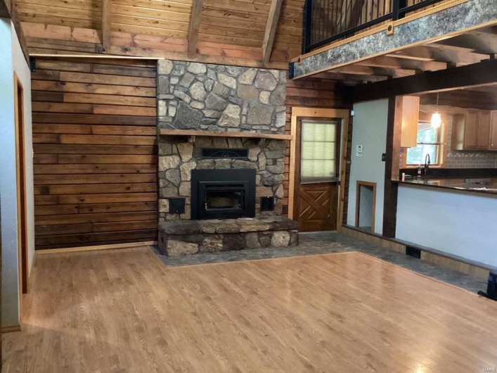 Unfurnished living room featuring wood-type flooring, a fireplace, wood ceiling, and beamed ceiling