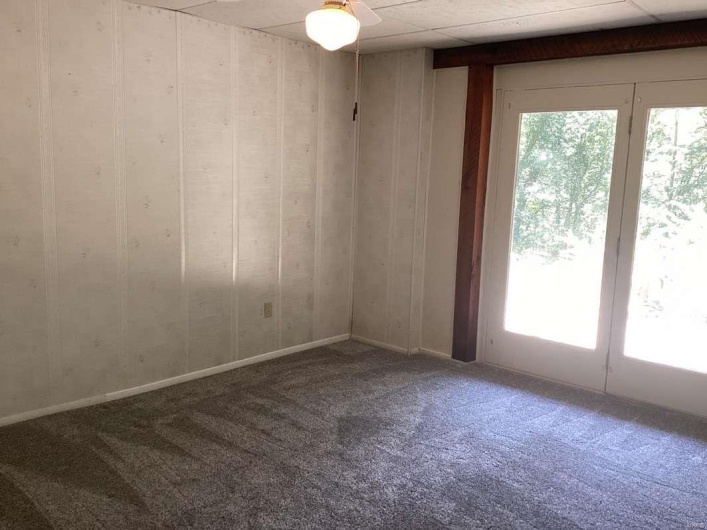 Unfurnished room featuring carpet floors and ceiling fan