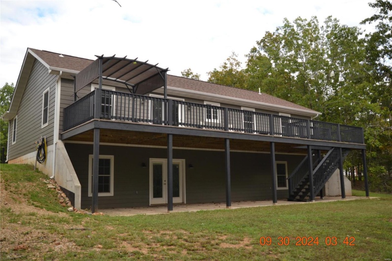 Rear view of house featuring a yard and a wooden deck