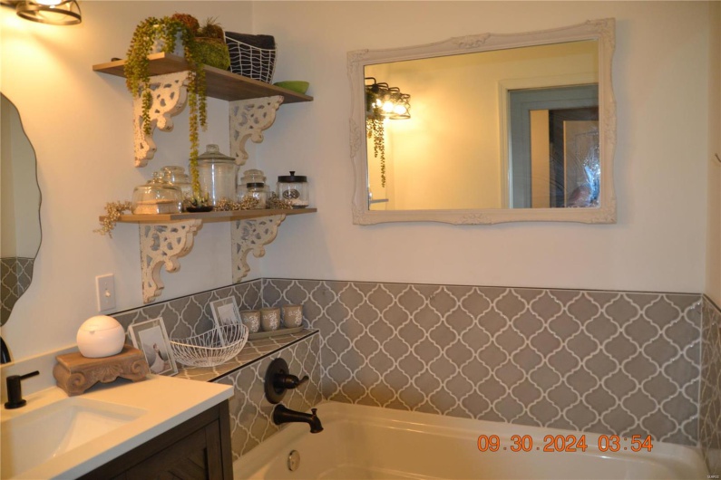 Bathroom featuring vanity and a tub