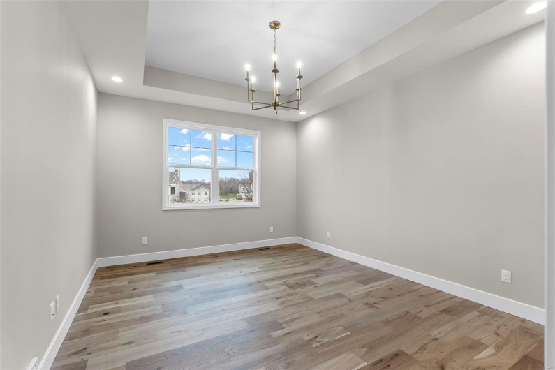 Unfurnished room with light hardwood / wood-style floors and a chandelier