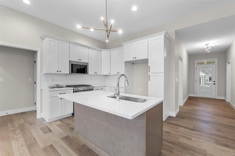 Kitchen featuring white cabinets, appliances with stainless steel finishes, and sink
