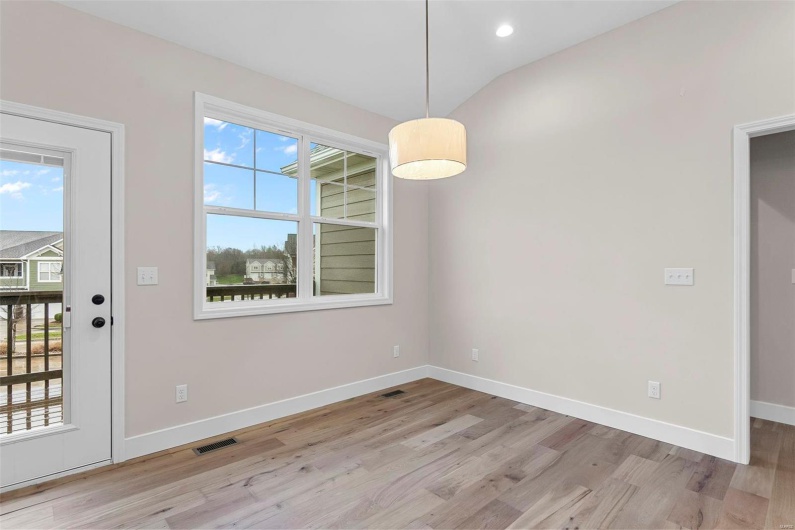 Unfurnished dining area with light hardwood / wood-style flooring and lofted ceiling