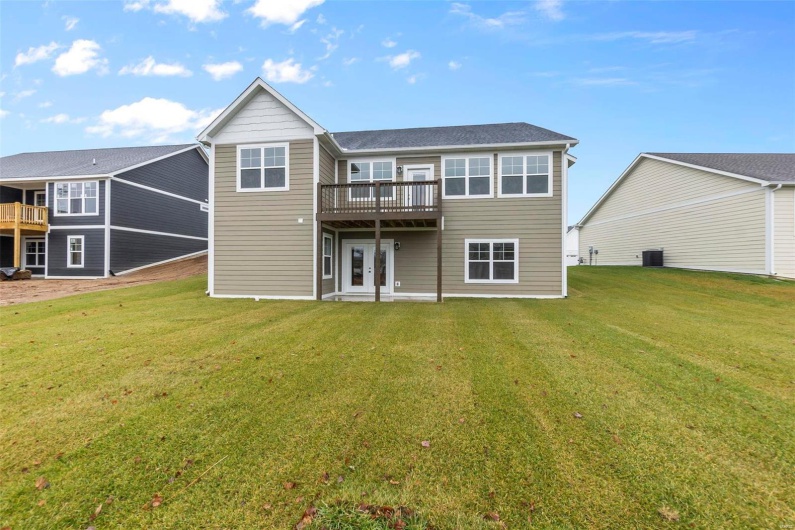 Back of house featuring a yard, a wooden deck, and central air condition unit