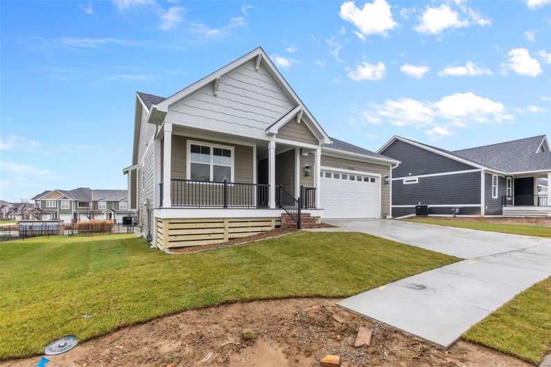 View of front of property with a front lawn, a porch, and a garage