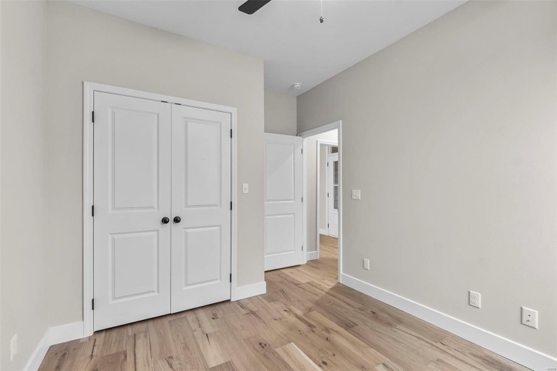 Unfurnished bedroom featuring a closet, light hardwood / wood-style floors, and ceiling fan