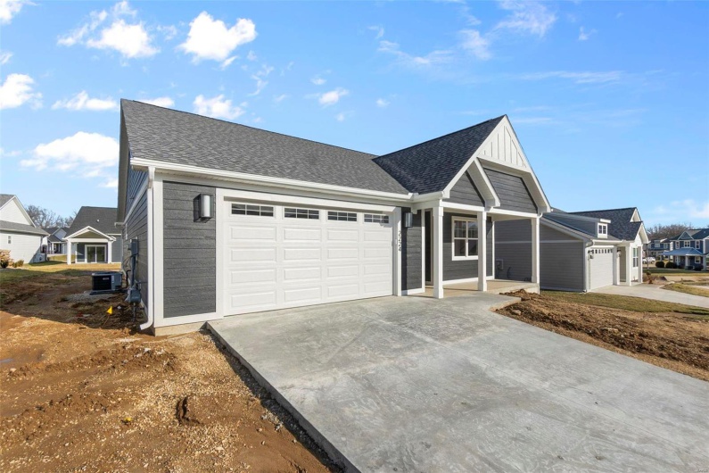 Ranch-style house featuring a garage, central AC unit, concrete driveway, and roof with shingles