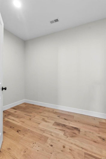 Unfurnished room with light wood-style floors, visible vents, and baseboards