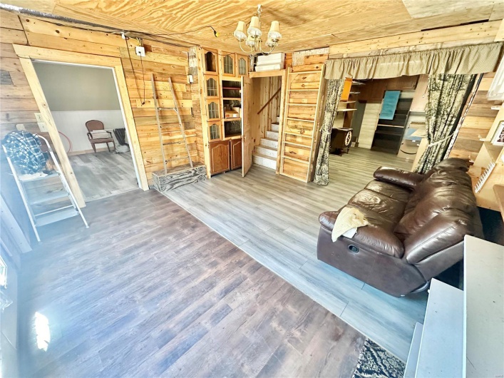 Living room with wooden walls, wood ceiling, and wood-type flooring