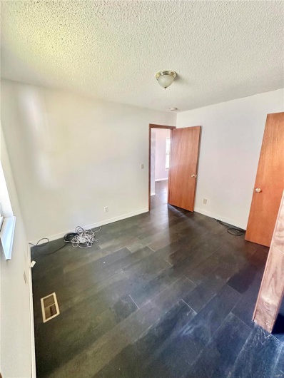 Spare room with dark hardwood / wood-style flooring and a textured ceiling