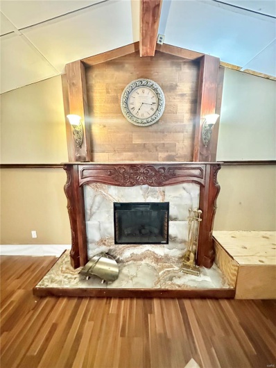 Details with a tiled fireplace and hardwood / wood-style floors