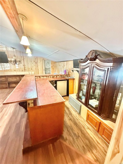 Bar featuring stainless steel appliances, wood walls, and sink